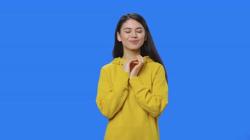 Woman Thinking in Yellow Hoodie on Blue Screen