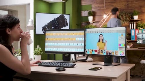 Woman Working at Dual Monitor Computer in Office