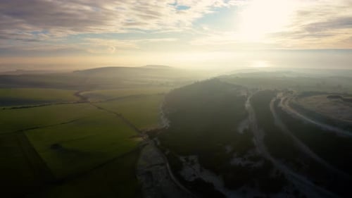 Scenic Sunrise Over Rolling Hills and Fields