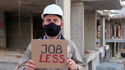 Construction Worker Holding Jobless Sign at Site