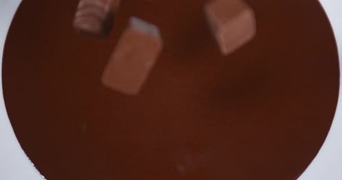 Chocolate Pieces Falling into Melted Chocolate