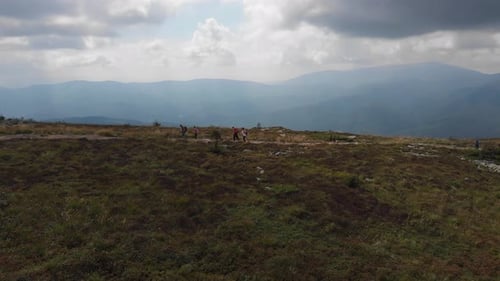 Luftaufnahme einer reisenden Familie beim Wandern durch epische Berge. 4K