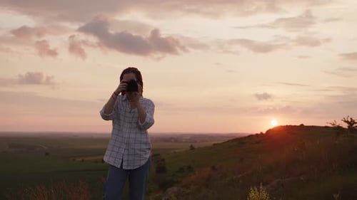 Young Woman Photographing Rural Landscape at Sunset