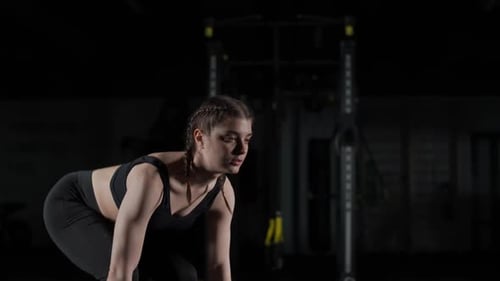 Woman Performing Overhead Press with Barbell in Gym