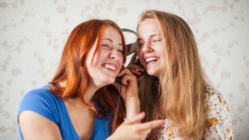 Two Young Women Singing with Headphones