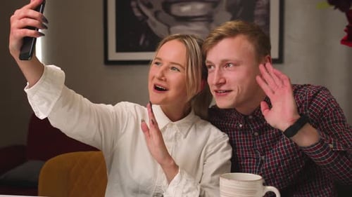 Smiling Couple Waving During Video Call