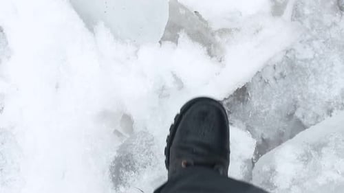 Legs of Man Walking on Snow with Footprints on Snowy Day