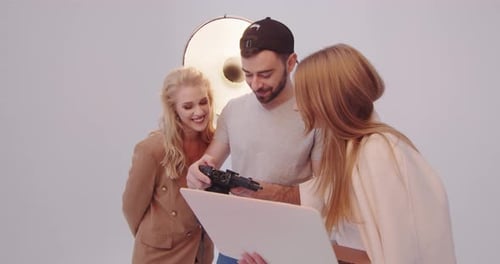 Team Collaborating with Camera and Laptop in Studio