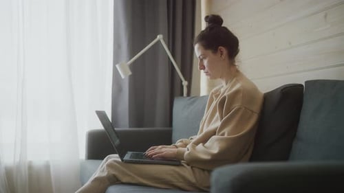Concentrated woman works on laptop