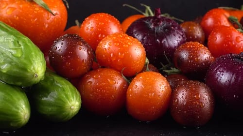 Fresh Vegetables: Tomatoes and Cucumbers with Water Droplets