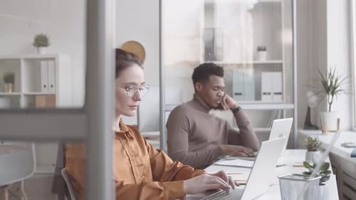 Caucasian Woman and Colleagues Working on Laptop in Quiet Office