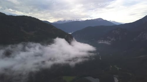 AERIAL: Malerischer Blick auf die Berge mit Wald und Schnee im Hintergrund, Winter