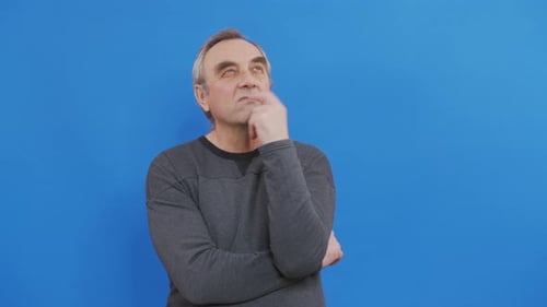 Thinking Elderly Man Looking Up Around Blue Background