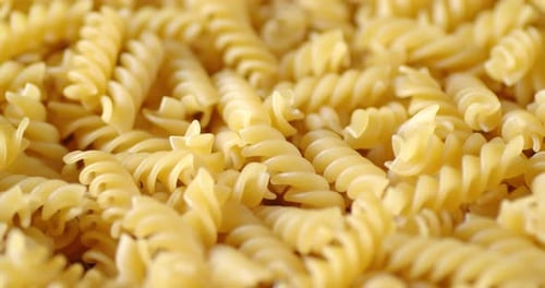 A Lot of Dry Pasta Fusilli Rotates Slowly.