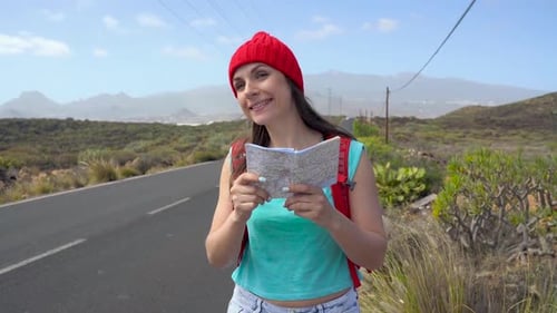 Mulher viajante pedindo carona em uma estrada ensolarada e caminhando
