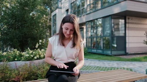 Woman Using Tablet Device Outside Office Building