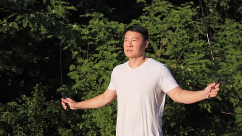 Man Jumps Rope for Fitness in a Park