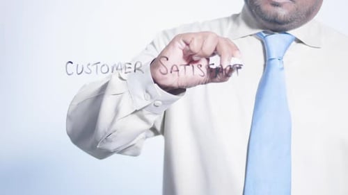 Man Writes Customer Satisfaction on Clear Surface