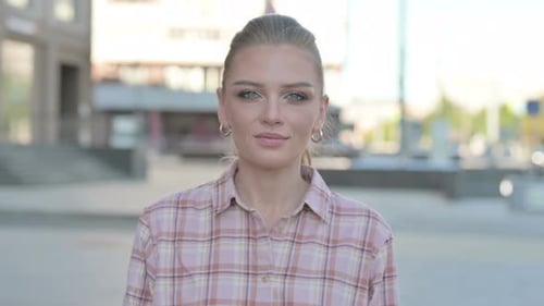 Portrait of Young Woman Looking at the Camera Outdoor