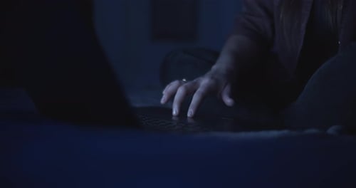 Woman Working on Laptop at Night Indoors