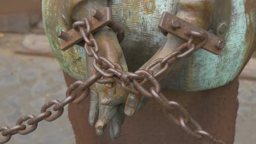 Statue of Bound Hands with Rusty Metal Chains