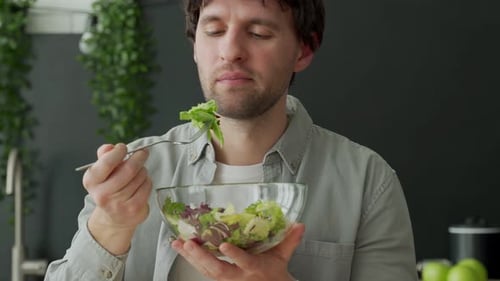 Young Adult Man Enjoying Healthy Salad at Home