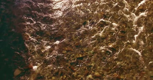 Flug in geringer Höhe über den frischen Fast Mountain River mit Felsen am sonnigen Sommermorgen