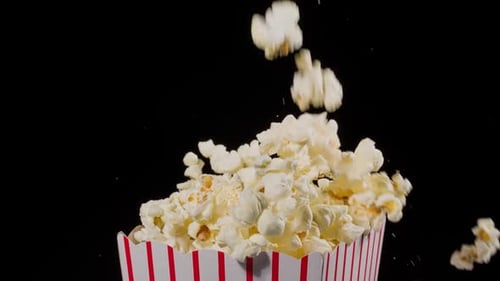 Popcorn falling in slow motion into a popcorn bucket