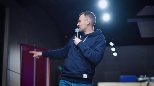 A Young Charismatic Man Makes a Presentation in a Dark Auditorium