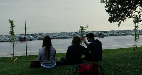 People Chatting by the Water in an Urban Park