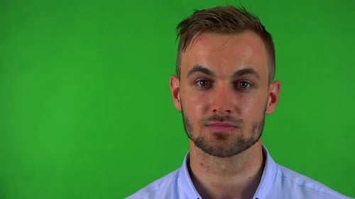Junger gutaussehender Geschäftsmann schaut mit ernstem Gesicht in die Kamera - Greenscreen - Studio - Nahaufnahme