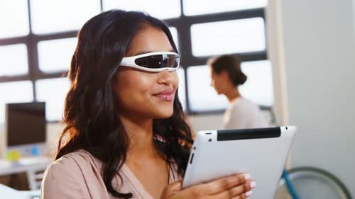 Woman Smiling Using Tablet Wearing Smart Glasses