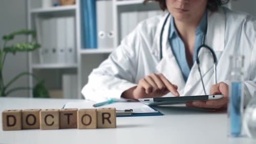 Girl Doctor Fills Papers, Working Doctor Doctor Office With Tablet. Head Physician Is Sitting Table