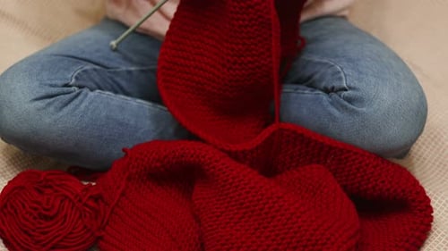 Woman Knitting with Needles and Red Yarn