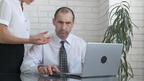 Man Working at Laptop Gets Feedback in Office