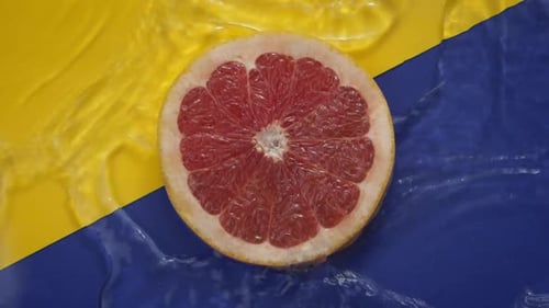 Half Grapefruit Washed with Water on Colorful Background