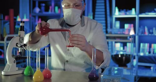 Scientist Pours Red Liquid in Research Laboratory