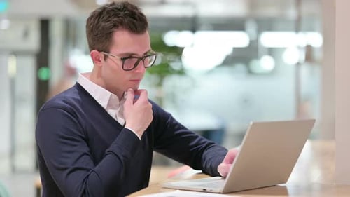 Man Working on Laptop at Modern Office
