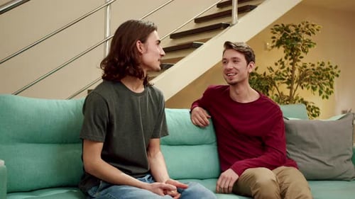 Two Men Talking on Couch in Bright Modern Home