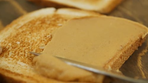 Peanut Butter Being Spread On Toast Slice