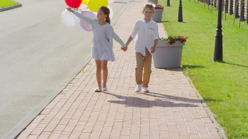 Children Running with Balloons on a Sunny Day