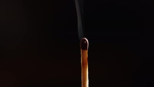 Burning Match Close Up Against Dark Background