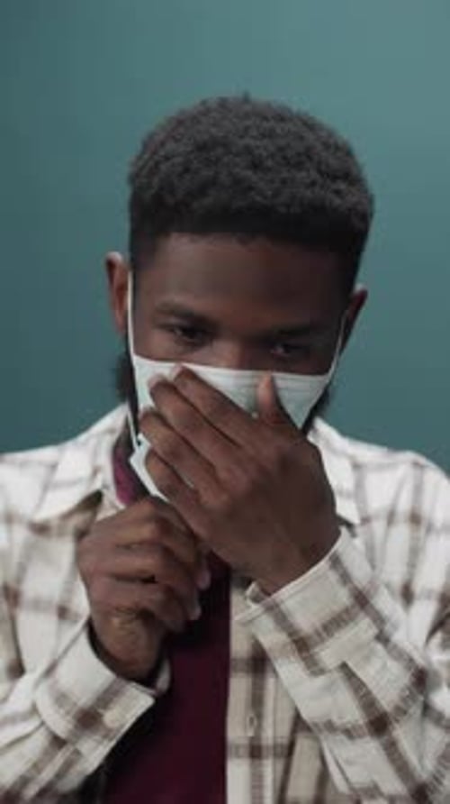 Young Adult Putting on a Medical Face Mask