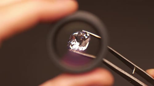 Close-up of a sparkling gem inspected through a loupe