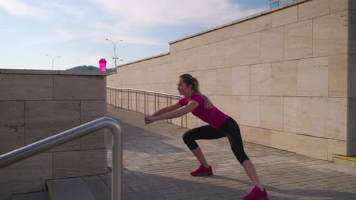 Woman is Doing Physical Exercises in Morning Outdoors Workout Alone in City