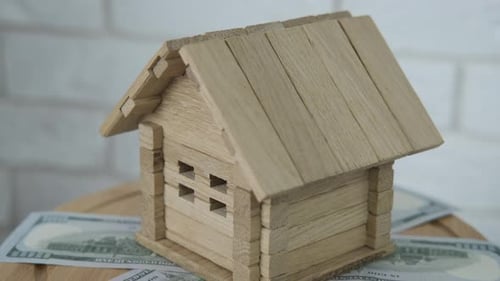 Wooden House on Money Symbolizing Home Investment
