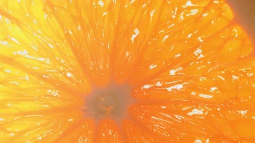 Drop of Water Flows Down the Surface of a Ripe Juicy Orange Slice