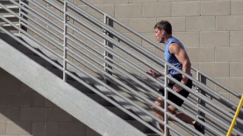 Athletic Man Sprinting Up Outdoor Metal Stairs