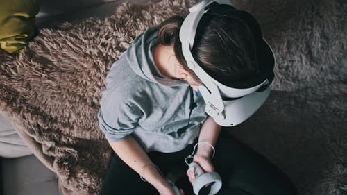 Woman Uses Virtual Reality Headset and Controllers at Home