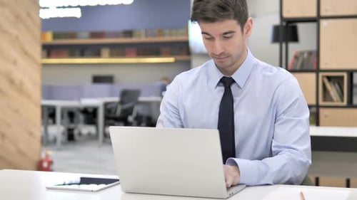 Man Working on Laptop in Bright Modern Office
